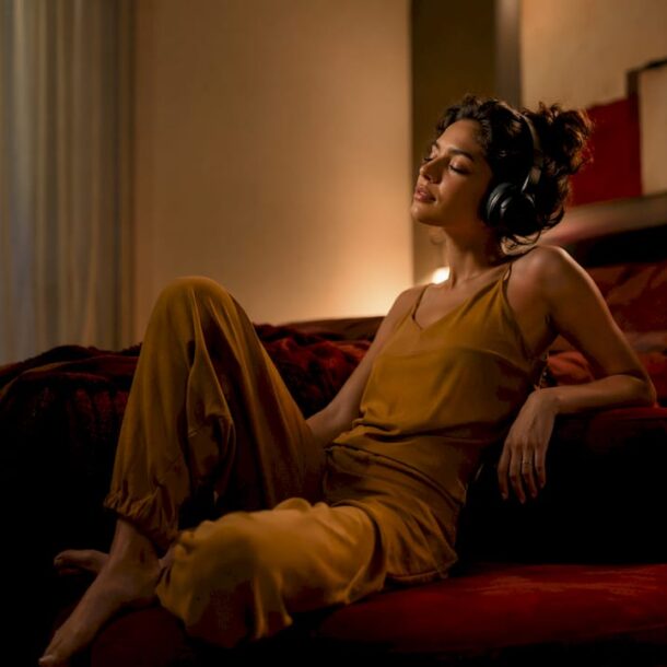 Woman relaxing with headphones in living room at night